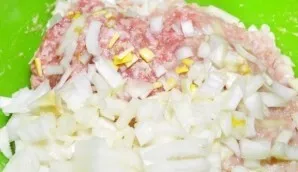 Nulupkite ir smulkiai supjaustykite svogūną. Sudėkite jį į maltą mėsą.