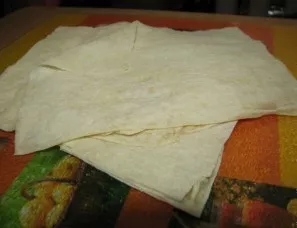 Didelį lavašo lakštą supjaustykite į 8 lygias dalis. Kiekvienas dydis yra maždaug 15 x 15 cm.