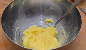 Suminkštintą margariną sutrinkite su cukrumi. Įjunkite orkaitę ir įkaitinkite iki 200 laipsnių.