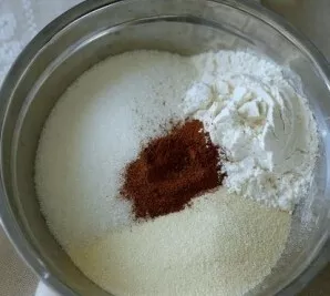 Pirmiausia sumaišykite visus birius ingredientus – miltus, manų kruopas, cukrų, kepimo miltelius ir cinamoną.