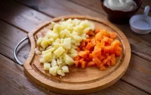 Išvirtas bulves ir morkas nulupkite ir supjaustykite mažais kubeliais.