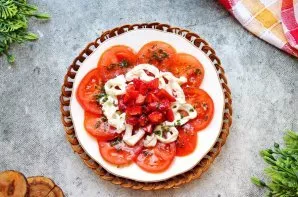 Užpilkite paruoštu bazilikų padažu stracciatella su braškėmis ir pomidorais ir nedelsdami patiekite.