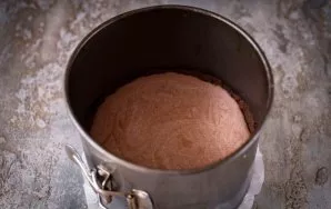 Sudėkite šį šokolado mišinį į formą su pagrindu. Švelniai pastuksenkite formelę į stalą, kad išleistumėte oro burbuliukus. Įkaitinkite or...