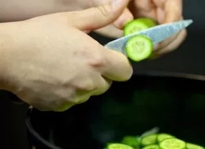 Agurkus supjaustykite plonais žiedeliais ir suberkite į salotas. Jei agurkai seni, nulupkite juos.