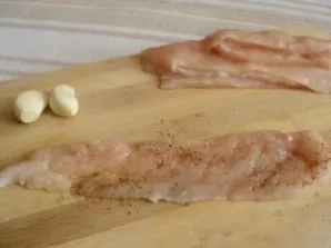 Vištieną supjaustykite gabalėliais, kiekvieną lengvai pamuškite plaktuku. Įtrinkite druska, česnaku ir pipirais.