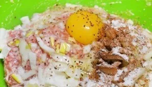 Taip pat į faršą įberkite druskos, pipirų ir įmuškite kiaušinį. Gerai išmaišykite ingredientus.