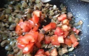 Ir tada į keptus grybus suberkite smulkiai pjaustytą pomidorą. Įberkite druskos pagal skonį ir kepkite dar 3 minutes.