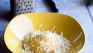 Smulkia tarka sutarkuokite sūrį ant svogūno. Sudėkite ingredientus į salotų dubenį.
