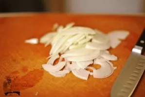Svogūną supjaustykite pusžiedžiais.