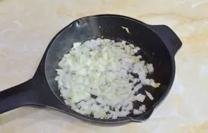 Į karštą keptuvę supilkite šiek tiek alyvuogių aliejaus ir suberkite susmulkintą svogūną. Kepkite maišydami 1-2 minutes. Jis taps minkšte...