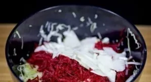 Svogūną nulupkite, supjaustykite plonais pusžiedžiais ir suberkite į salotas.