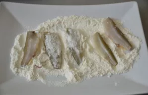 Žuvį apvoliokite miltuose, įberkite druskos ir juodųjų pipirų.
