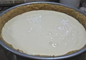 Paruoštą mišinį supilkite į kepimo formą su paruoštu pagrindu. Pakraštyje turi likti pakankamai vietos, kad po kepimo būtų galima užpildy...