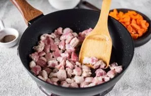 Keptuvėje ant stiprios ugnies įkaitinkite augalinį aliejų ir sudėkite kiaulienos gabalėlius. Kepkite mėsą, kol ji lengvai pagels, nuolat ...