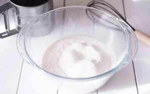 Į mielių mišinį išsijokite 100 gramų miltų.