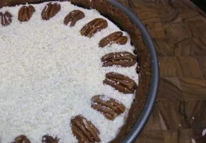 Iškepus sūrio pyragą šiek tiek atvėsiname. Grietinę išplakti su baltuoju šokoladu. Dėkite ant gatavo sūrio pyrago ir papuoškite likusiais...