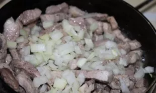 Iš pradžių į keptą mėsą suberiu smulkintą svogūną, tada išmaišau.