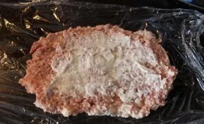 Ant stalo išskleiskite maistinę plėvelę. Ant jos dedame dalį faršo. Patepame kreminiu sūriu.