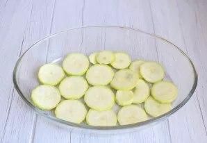 Nulupkite cukinijas. Supjaustykite 0,3-0,5 cm storio griežinėliais.
