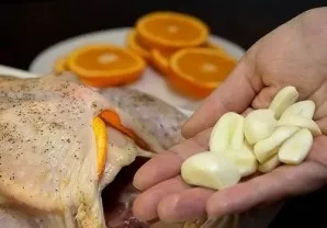 Nuluptą česnaką šiek tiek supjaustykite ir gabalėlius sudėkite į vištienos vidų.