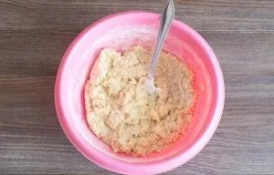 Pradėkite minkyti tešlą šakute. Kai tik pradės formuotis gumuliukai, minkykite rankomis.