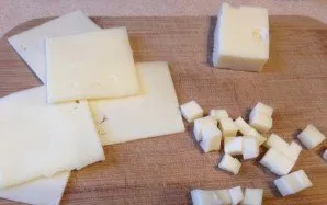 Sūrį supjaustykite plonais griežinėliais. Reikėjo sunaudoti visą sūrį, tai dalį supjausčiau kubeliais.