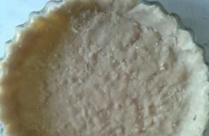 Paimkite 24-26 cm skersmens kepimo formą, lengvai patepkite ją augaliniu aliejumi, rankomis paskleiskite 2/3 tešlos, suformuodami šonus.