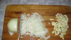 Toliau smulkiai supjaustykite svogūną ir česnaką.