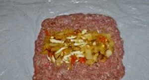 Maltą mėsą padalinkite į dvi dalis. Stalą padengiame maistine plėvele, ant kurios vėliau dedame dalį faršo, suformuodami stačiakampį sluo...