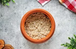Miežines kruopas nuplaukite ir sudėkite į puodą ant mėsos.