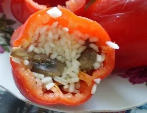 Paruošiame įdarą paprikoms. ryžius ir keptus grybus sumaišyti su svogūnais ir morkomis. Įberkite druskos ir pipirų. Gautu įdaru įdarome p...