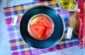 Sterilizuokite pomidorus su svogūnais ir aliejumi 5 minutes. Patogu į puodą įpilti šilto vandens, o apačioje po stiklainiu padėkite švari...