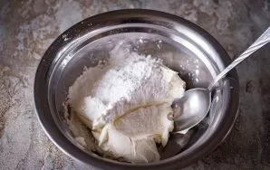 Visą kreminį sūrį sudėkite į didelį dubenį ir suberkite cukraus pudrą. Šiuos ingredientus sumaišykite šaukštu iki vientisos masės, jokiom...