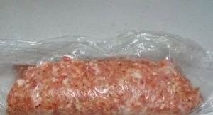 Ir plėvele susukame ritinį, atsargiai užsandarindami siūles ir kraštus. Tą patį darome su likusiu faršu ir įdaru.