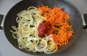 Keptuvėje, kurioje kepėte žuvį, pakepinkite svogūną ir morką, supilkite pomidorų pastą ir vėl kepkite, su pasta, 3-5 minutes.