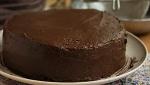 Likusį kremą paskirstykite ant šonų ir viršaus. Tortą padėkite 2-3 valandoms į šaldytuvą. Ištirpinkite šokoladą ir įpilkite šaukštą bekva...